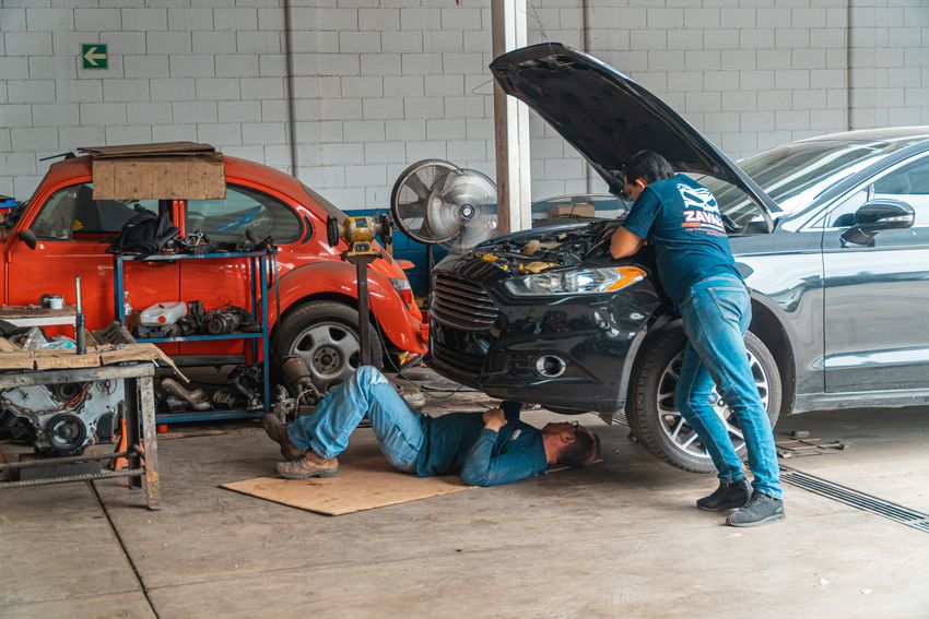 Zespół mechaników pracujących przy samochodach